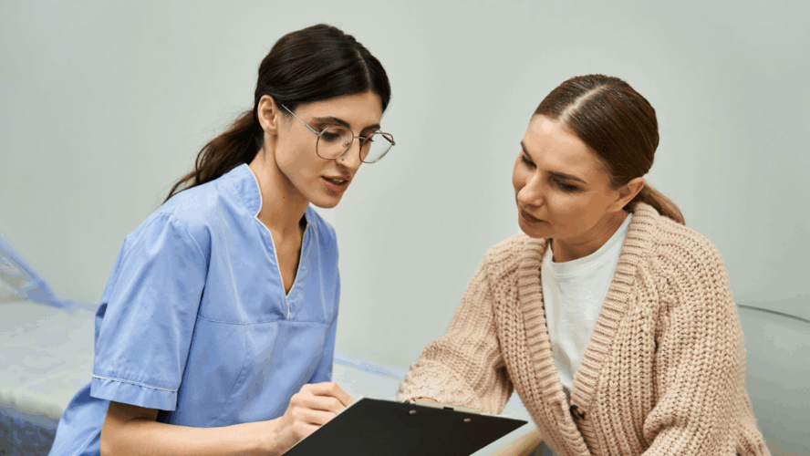 A professional gynecologist discusses health concerns with a patient in a contemporary clinic.