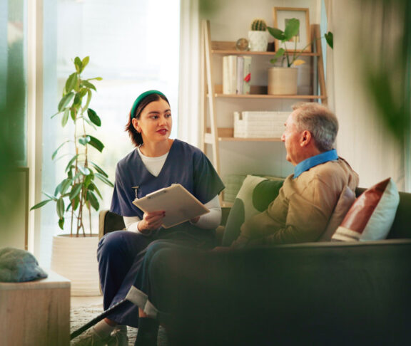 Caregiver, clipboard and senior man on sofa for assisted living, medical service and diagnosis in nursing home. Retirement, healthcare and nurse with elderly person for consulting, support and help