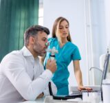 Adult man testing breathing function by spirometry having health problem. Diagnosis of respiratory function in pulmonary disease.