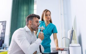 Adult man testing breathing function by spirometry having health problem. Diagnosis of respiratory function in pulmonary disease.