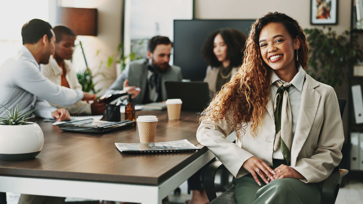 Collaboration, portrait and smile of business woman in boardroom with colleagues for planning. Corporate, face and meeting with happy African employee in professional workplace for career development