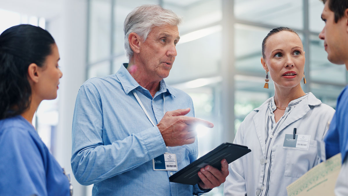 Doctors, group and tablet for hospital management with discussion for funding, planning and review. Director, leader and team with surgeon, nurse and feedback with application at wellness