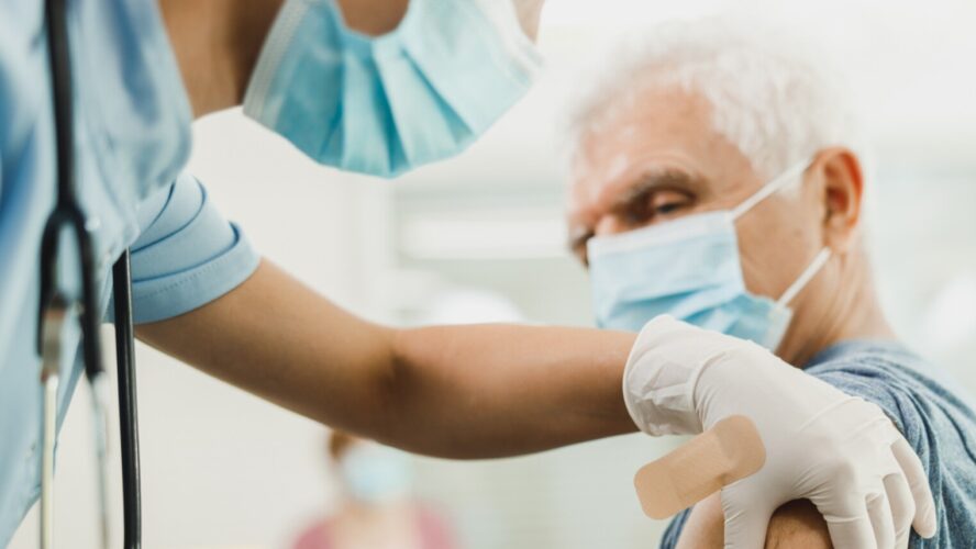 A nurse giving a vaccine to senior man