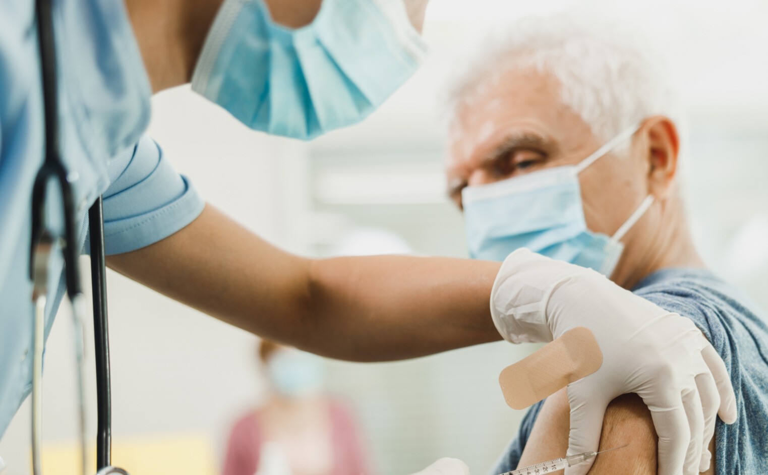A nurse giving a vaccine to senior man