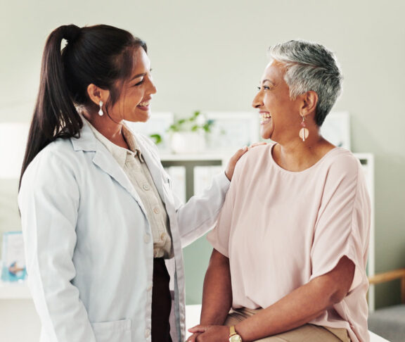 Clinic, doctor and check up with mature woman, discussion and healthcare, service and consultation. Hospital, caregiver and person with patient in office, test and support of medical professional