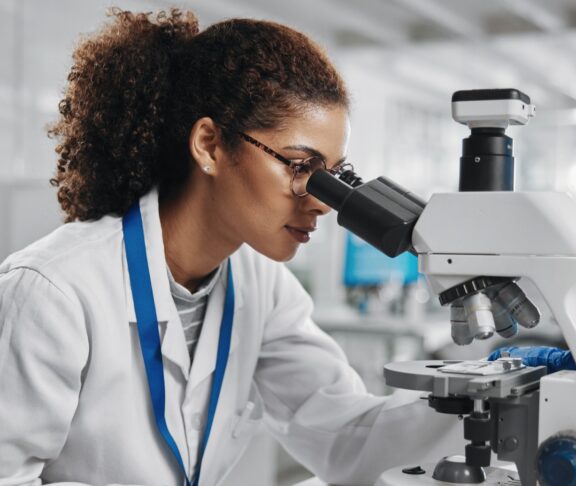 Microscope, woman check and virus research of science study with healthcare, scientist and laboratory work. Analysis, testing and medical professional with investigation for scientific journal - stock photo