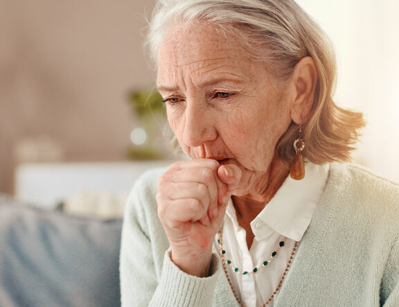 Senior, sick woman and cough with viral infection for chronic illness, influenza or virus at home. Elderly, female person or cold with hayfever, bronchitis or flu symptoms for lung disease or sinus