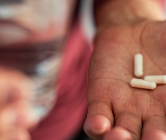 Senior man taking a pill in a bathroom