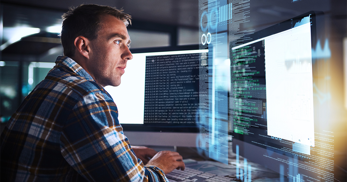 programmer working at his computer with an overlay of computer graphics