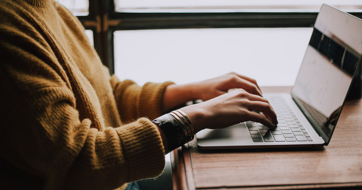 Close up shot of someone typing on a laptop