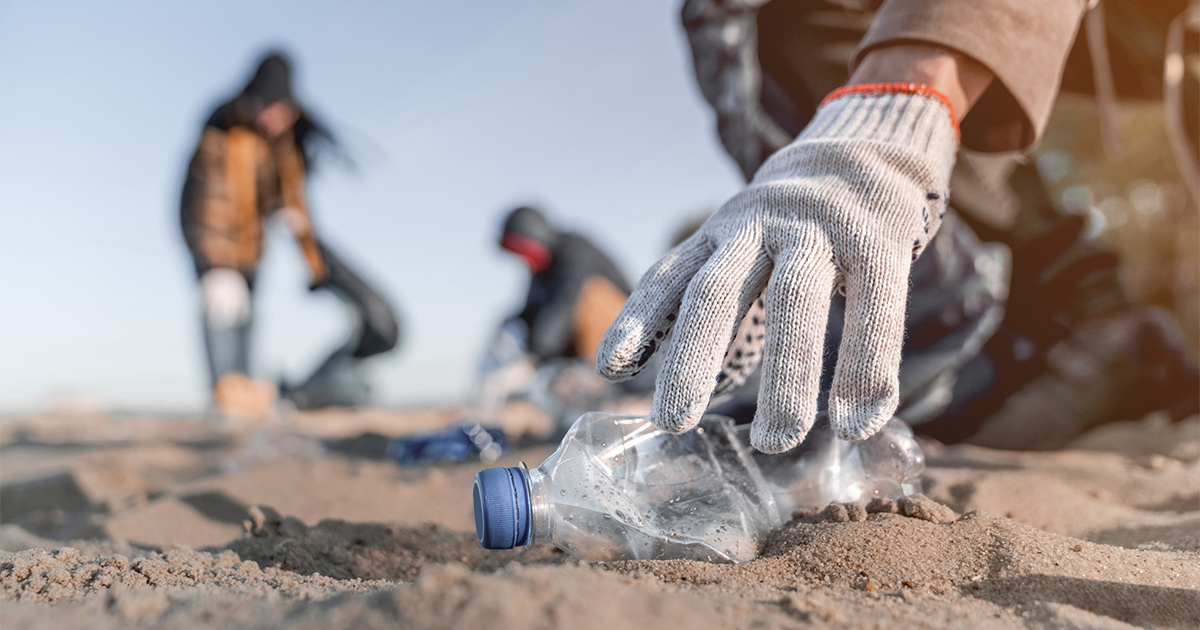 Volunteer man collecting trash on the beach. Ecology concept