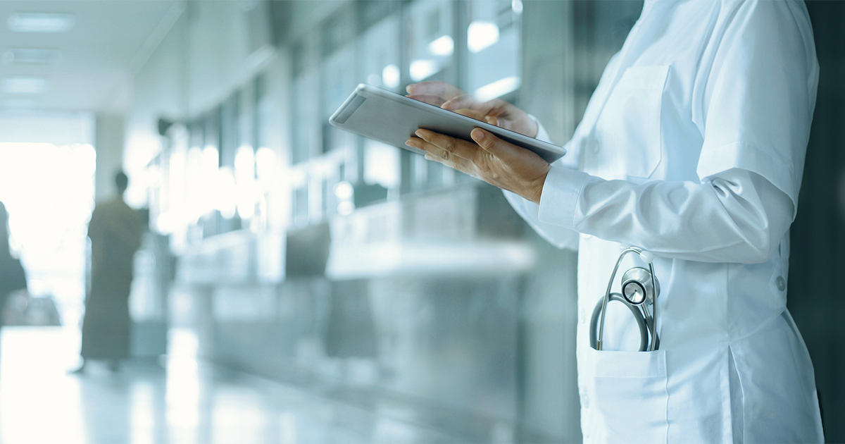 Doctor working on digital tablet on hospital background