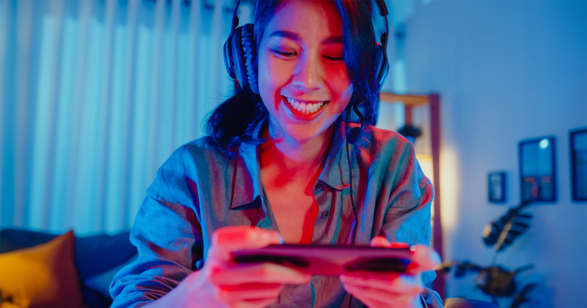 girl gamer wear headphone competition play video game online with smartphone