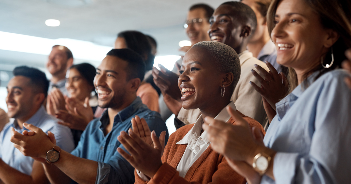 Shot of a group of young businesspeople clapping during a conference in a modern office