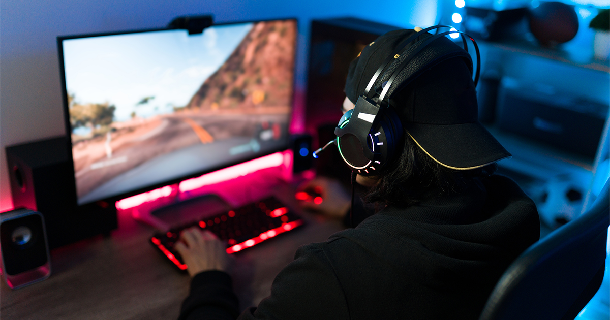 gamer sitting at his bedroom desk and playing an online video game