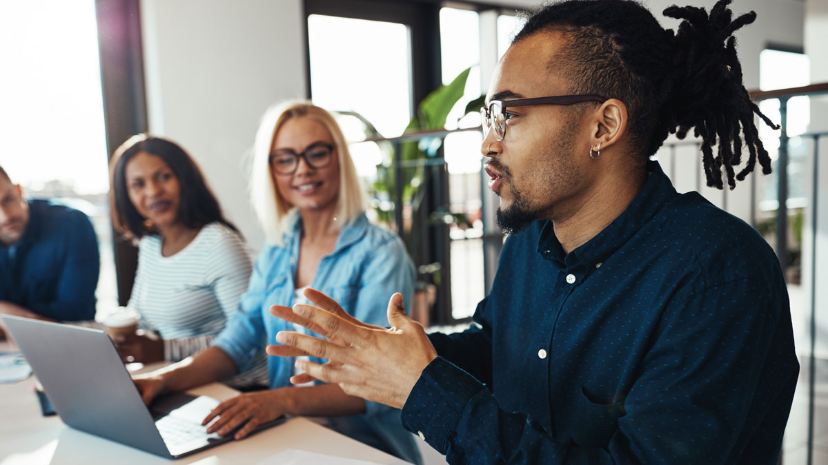 Young African American businessman discussing work with office