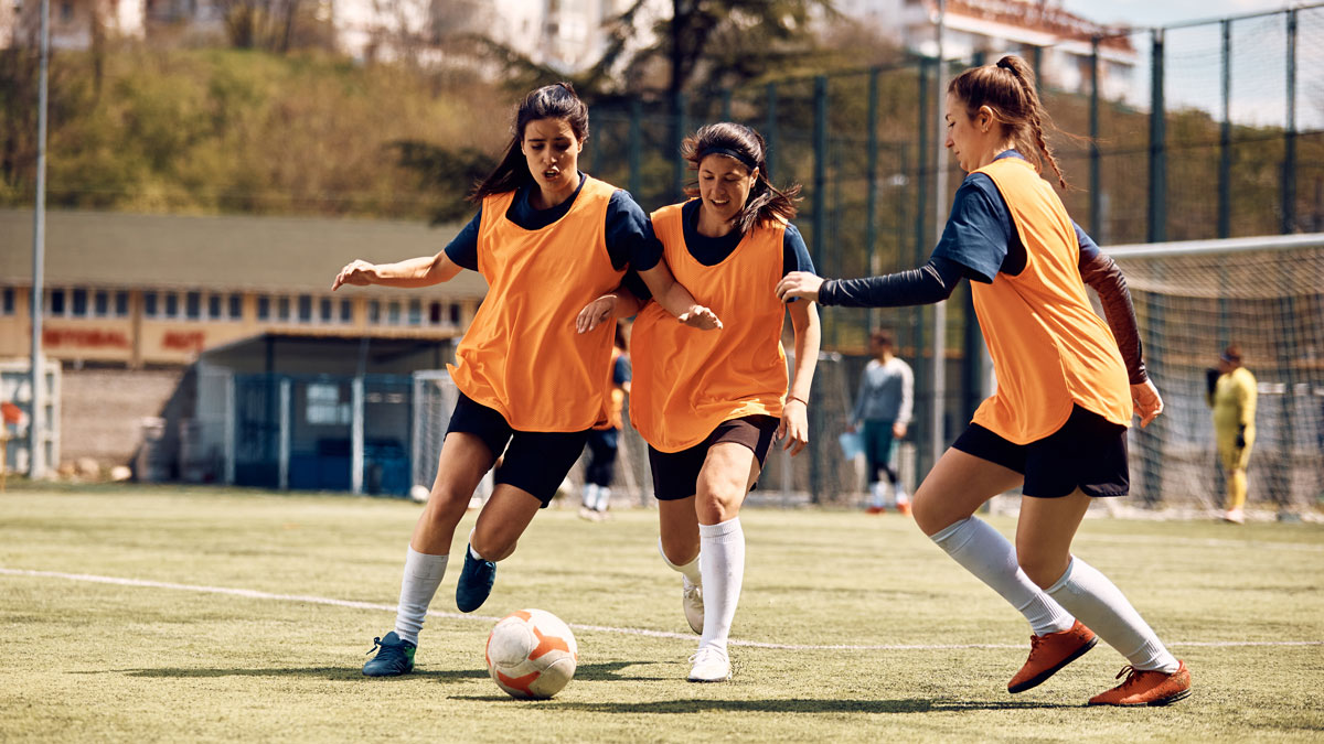 Athletic women play soccer on sports training at stadium