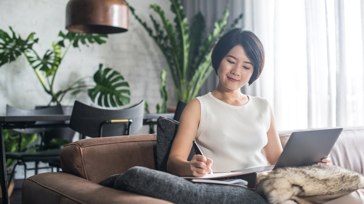 Happy Asian woman using the computer at home.
