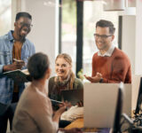 Young happy start-up team talking during business meeting in the office.
