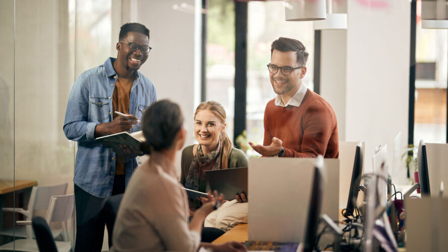 Young happy start-up team talking during business meeting in the office.