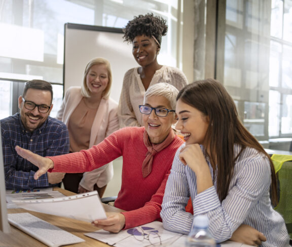 Senior designer giving some new ideas about project to her partners in conference room. Business people discussing over new business project in office. Group of businesspeople or designers work with new startup project in office