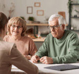 Senior couple sitting at the table with realtor and have a consultation about financial documents at home