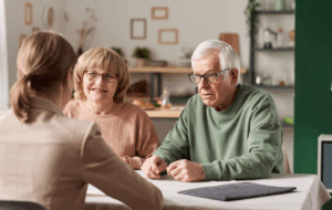 Senior couple sitting at the table with realtor and have a consultation about financial documents at home