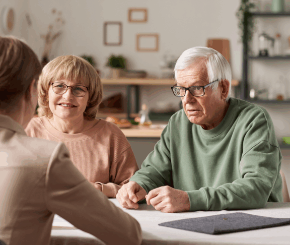 Senior couple sitting at the table with realtor and have a consultation about financial documents at home