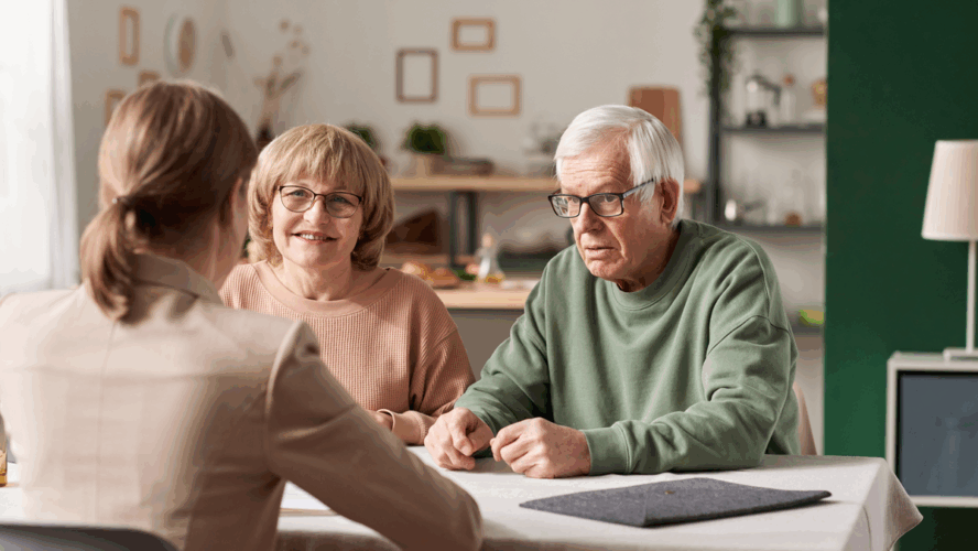 Senior couple sitting at the table with realtor and have a consultation about financial documents at home