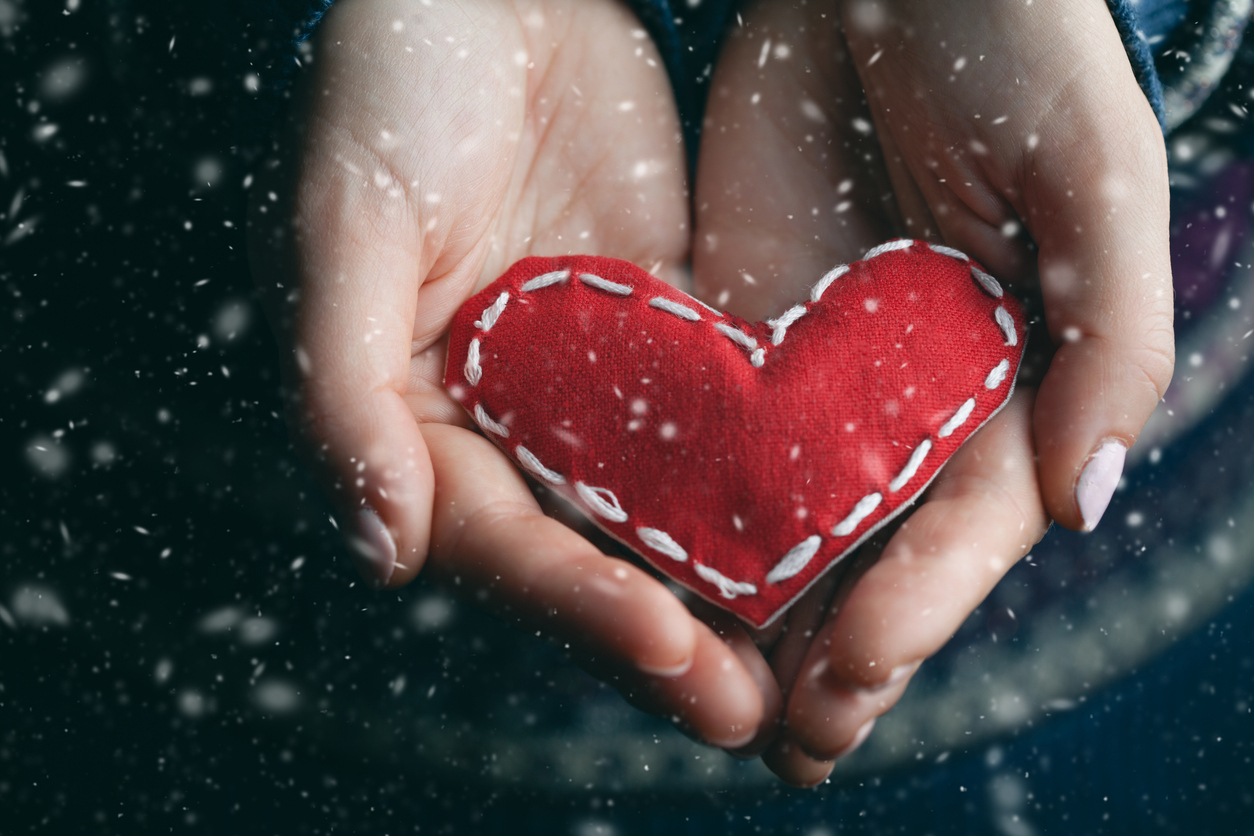 Female hands giving red heart