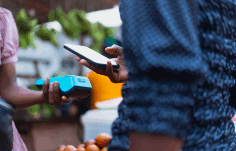 Extreme Nahaufnahme Bild zeigt die moderne NFC-Zahlungsmethode, mit Händen, die ein POS-Terminal und ein Mobiltelefon halten.