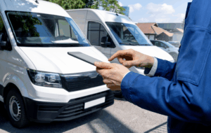 Manager mit einem digitalen Tablet auf dem Hintergrund von Vans. Flottenmanagement