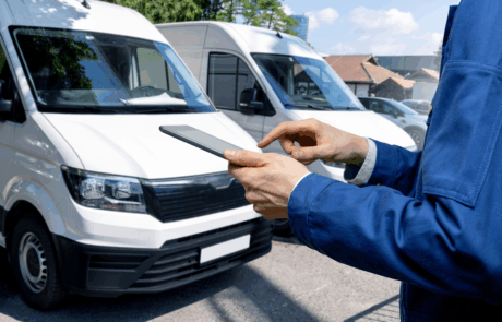 Manager mit einem digitalen Tablet auf dem Hintergrund von Vans. Flottenmanagement