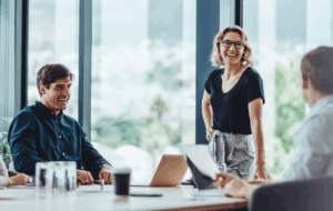 Gruppe von Kollegen, die während eines Geschäftstreffens in einem Konferenzraum ein Gespräch führen. Zufriedene Geschäftsleute, Männer und Frauen, die zusammenarbeiten und auf ihre gemeinsamen Ziele hinarbeiten.