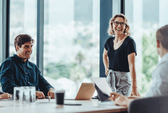 Gruppe von Kollegen, die während eines Geschäftstreffens in einem Konferenzraum ein Gespräch führen. Zufriedene Geschäftsleute, Männer und Frauen, die zusammenarbeiten und auf ihre gemeinsamen Ziele hinarbeiten.