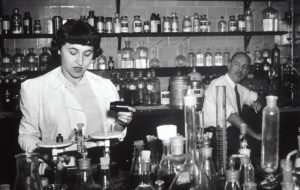 schwarz weiß Bild in einer alter Apotheke, ein Mann und eine Frau abgebildet