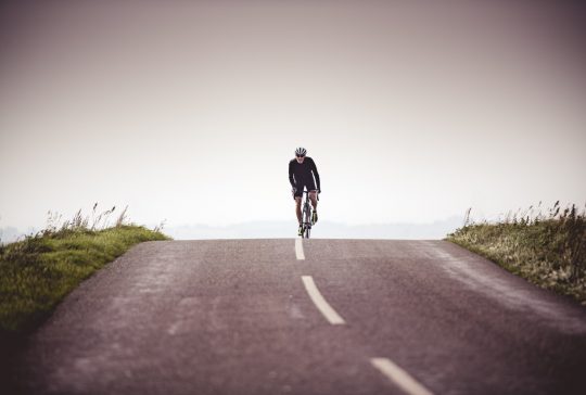 Portrait of a fit 50 year old male cyclist out of a training ride. Photographed in a modern contemporary style, colour, horizontal with some copy space. Photographed on the island of Møn in Denmark.