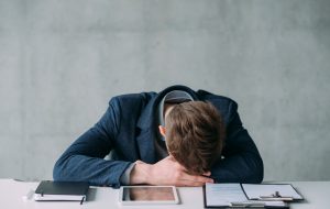 Office routine. Projects and deadlines. Overtime schedule. Tired young male manager sleeping at work.