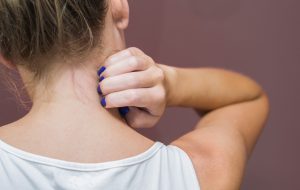 Great concept of allergy and skin diseases, young woman scratching herself.