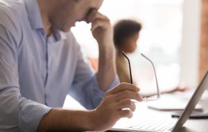 Eyestrain concept, tired mid aged businessman holding glasses rubbing dry irritable eyes fatigued from computer feel pain strain suffering from bad vision, eyesight tension problem at work, close up