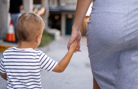 Mutter hält Hand ihres Sohnes während sie spazieren