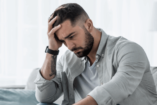 Attraktive Kerl Gefühl verzweifelt, traurig, Blick beunruhigt depressiv nachdenklich und einsam leiden Depressionen auf der Couch zu Hause im mittleren Alter Krise, psychische Gesundheit persönliche Probleme und Lebensstil
