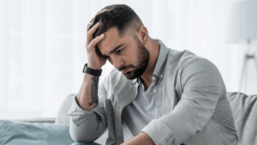 Attraktive Kerl Gefühl verzweifelt, traurig, Blick beunruhigt depressiv nachdenklich und einsam leiden Depressionen auf der Couch zu Hause im mittleren Alter Krise, psychische Gesundheit persönliche Probleme und Lebensstil