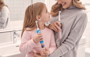 Kinder mit Familie und Oral B Zahnbürste