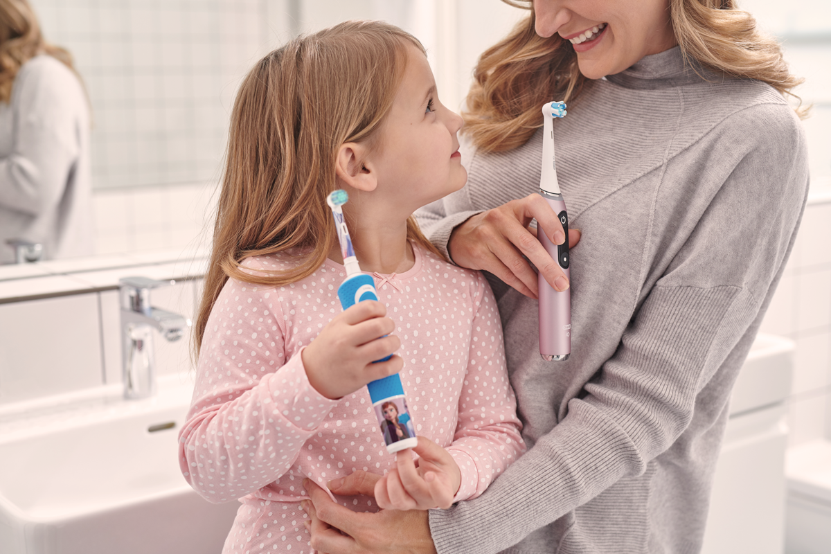 Kinder mit Familie und Oral B Zahnbürste
