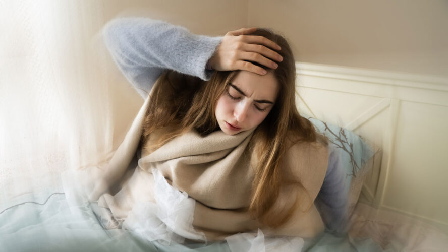 Kranke junge weiße Frau, die aus dem Bett steigt, ihren Kopf aufgrund von Schwindel, Migräne, Schwindel, Kopfschmerzen im Schlafzimmer zu Hause hält. Saisonale Kälteerscheinungen, Grippeepidemie, Fieber, Krankheit, Krankheit, Unwohlsein.