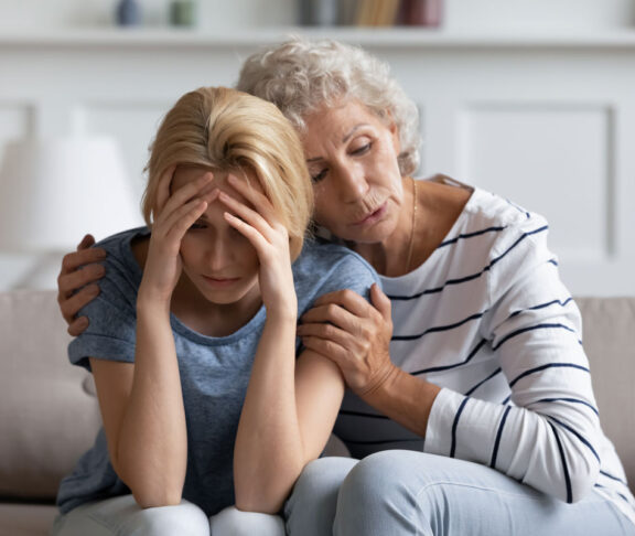 Wir werden es überwinden, lieber Schatz. ängstlich liebevolle, heimatliche Mutter beruhigend, tränkend unterstützende, depressive erwachsene Tochter leidet an schlechten Tag, Gesundheit oder Arbeitsschwierigkeiten, gefährliche Diagnose, Scheidung