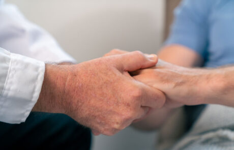 Arzt, der die Hände hält und den männlichen Patienten beruhigt. Medizinische Gesundheitsversorgung, Krankheitsdiagnose und Unterstützung bei der Kommunikation mit Empathie. Gesundheitstherapie, Psychotherapie, Wellnessberatung in der Klinik.