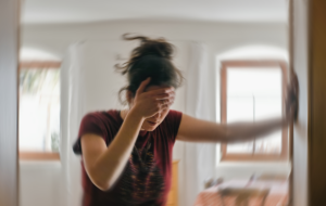 Unscharfes Foto einer Frau, die an Schwindel oder Schwindel oder anderen gesundheitlichen Problemen des Gehirns oder des Innenohrs leidet.