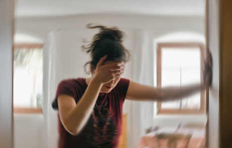 Unscharfes Foto einer Frau, die an Schwindel oder Schwindel oder anderen gesundheitlichen Problemen des Gehirns oder des Innenohrs leidet.